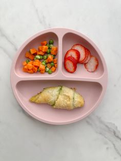 a pink plate topped with fruit and veggies