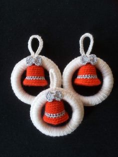 three red and white crocheted bells on black background