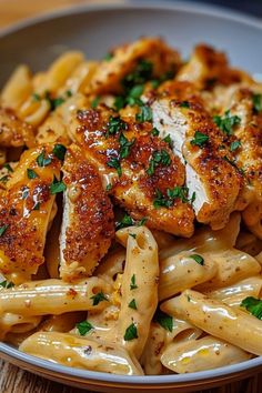 pasta with chicken and parsley in a white bowl on a wooden table, ready to be eaten