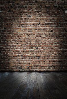 an old brick wall and wooden floor with light coming in from the top right corner