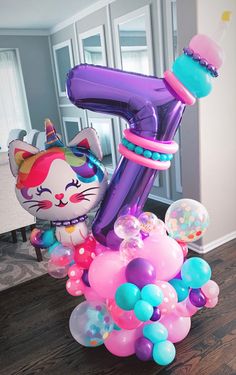 an inflatable number one balloon with a cat on top and balloons all around it