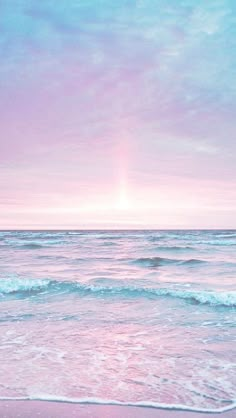 the sun is setting over the ocean with waves coming in to shore and pink sky