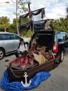 a man sitting in the back of a van with an open trunk filled with items