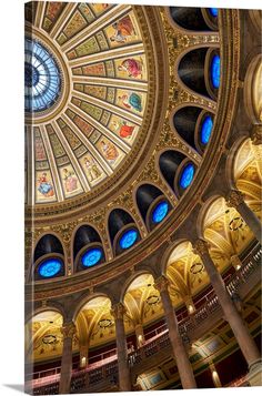 an ornate ceiling in the center of a building with blue and yellow glass panels on it