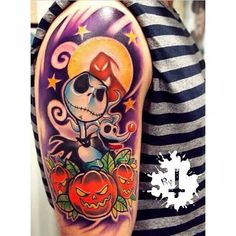 a person with a tattoo on their arm and some pumpkins in front of them