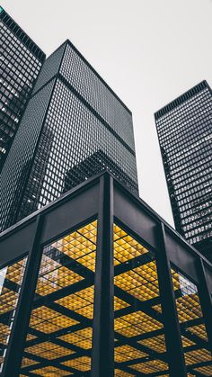 two tall buildings with yellow lights in front of them