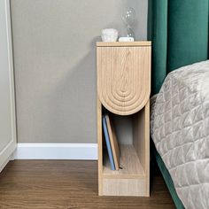 a nightstand next to a bed in a room with a green headboard and curtains