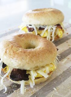 two bagels sitting on top of a cutting board