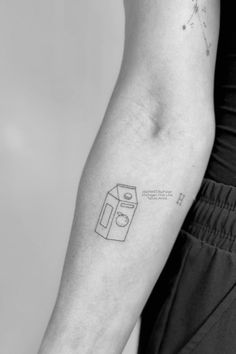 a black and white photo of a person's arm with a tattoo on it