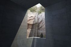 a person sitting on a ledge looking out at the mountains