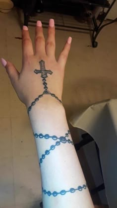 a woman's arm with a tattoo on it and a cross in the middle