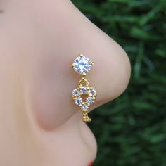 a close up view of the back of a woman's ear with two diamonds on it