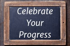 a sign that says celebrate your progress on the side of a wooden door with an arrow pointing to it