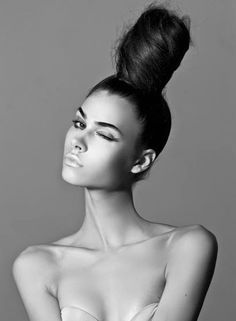 black and white photograph of a woman with her hair in a high pony tail bun