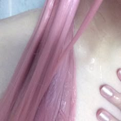 a woman with long pink hair and nails on her chest is shown from the top down