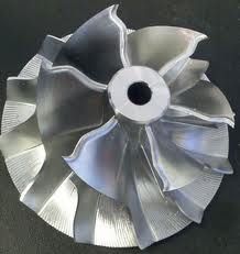 an aluminum fan blade on a black surface with the end cut out to show it's blades