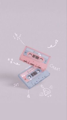 two pink cassettes sitting next to each other on top of a white surface with drawings all over them