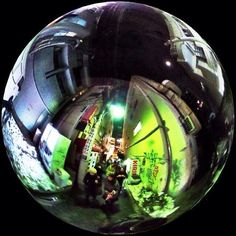 a fish eye view of people walking down the street in front of a building at night