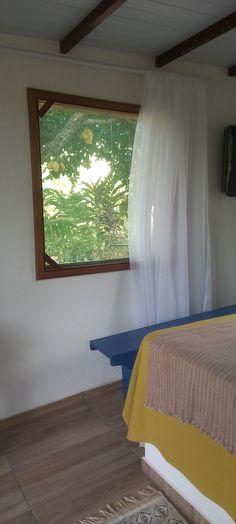 a bed sitting under a window in a bedroom