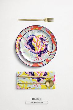 a colorful plate and fork on a white surface