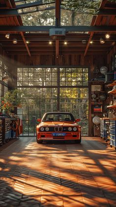 an orange car parked in a garage with lots of shelves on the wall and windows