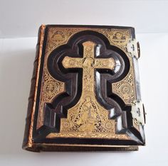 an ornate wooden box with a cross on it's front and side panels, sitting on a white surface