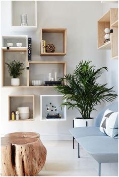 a living room filled with furniture and a tree stump table in front of a white wall