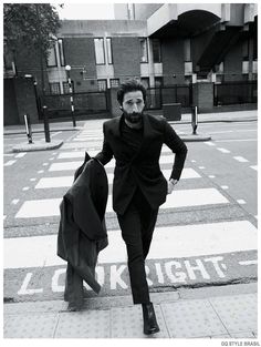 a man in a suit is walking down the street