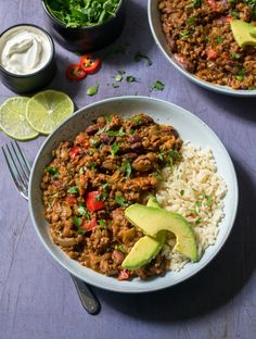 two bowls filled with rice, meat and veggies next to a bowl of sour cream