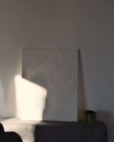 a white sculpture sitting on top of a gray couch