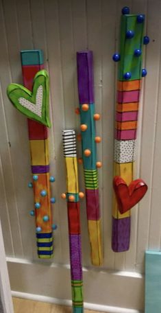 colorful toothbrushes are hanging on the wall in front of a door with hearts