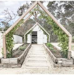 an outdoor garden with wooden steps leading up to the shed and doors on each side