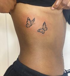 a woman's stomach with two butterflies on her side and the lower part of her abdomen