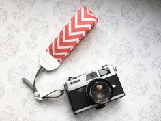 an old camera is laying next to a red and white bag