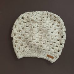 a white crocheted beanie on a brown surface