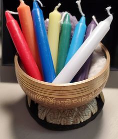 six candles in a wooden bowl on a table