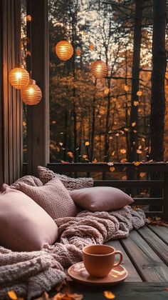 a coffee cup on a wooden deck with lights hanging from the trees in the background