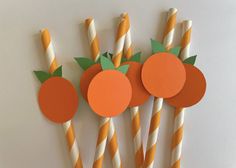 orange and white striped straws with paper fruit on them