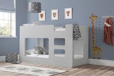 a child's bedroom with blue walls and white bunk beds, stuffed giraffes on the wall