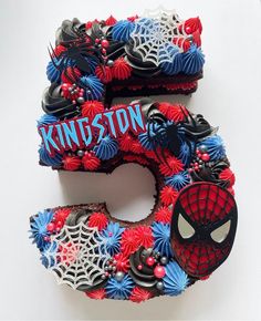 the letter e is made up of cupcakes and spiderman icing on it