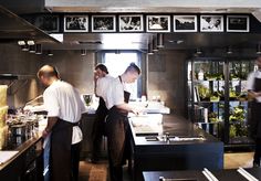 three chefs are in the kitchen preparing food for people to eat and drink at them