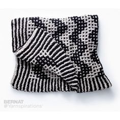 a black and white knitted blanket laying on top of a table