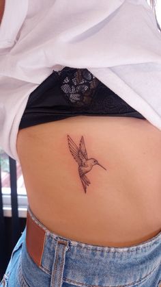 a woman's stomach with a small tattoo on the back of her lower body