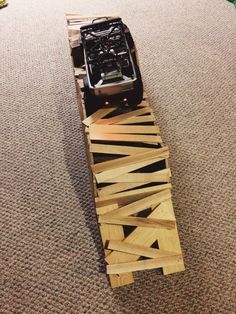 a toy car is sitting on top of a skateboard made out of wood planks