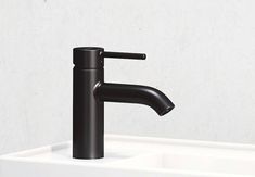 a black faucet sitting on top of a white sink