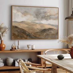 a painting hanging on the wall above a dining room table