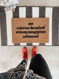 someone is standing in front of a door mat that says, no cotton headed nnnmyggins allowed