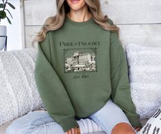 a woman sitting on a couch wearing a sweatshirt with the words pride and providence printed on it