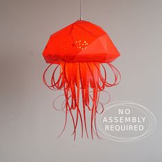 an orange jellyfish lamp hanging from a white wall with the words no assembly required