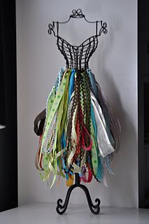 there is a dress made out of ties on a stand in front of a wall